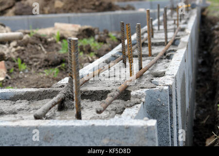 Nahaufnahme von Haus Fundament aus Beton Schalung Bausteine mit Mörtel und Verstärkungsleisten gefüllt Stockfoto