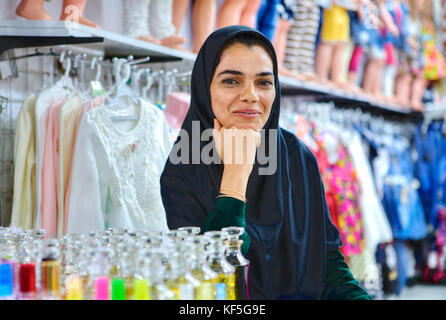 Shiraz, Iran - 19. April 2017: Porträt einer junge lächelnde Verkäuferin mit Kleidung und Parfums. Stockfoto