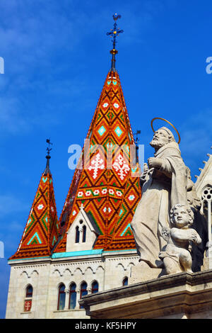Statue auf Dreifaltigkeitssäule und traditionellen Fliesen Dach der Matthiaskirche in Budapest Stockfoto