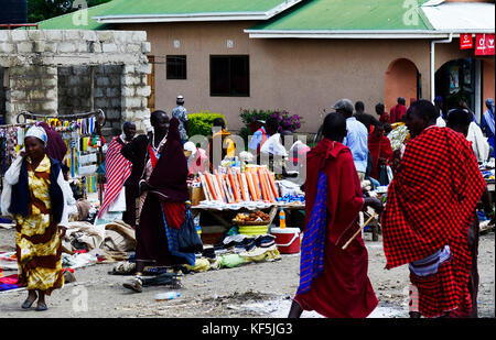 Maasai Stammesangehörige in einem bunten Vieh und frischen Produkten vom Markt im Norden von Tansania. Stockfoto