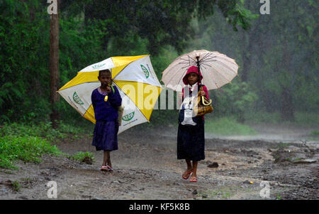 Tansanischen Kinder wandern in den starken Regen. Stockfoto