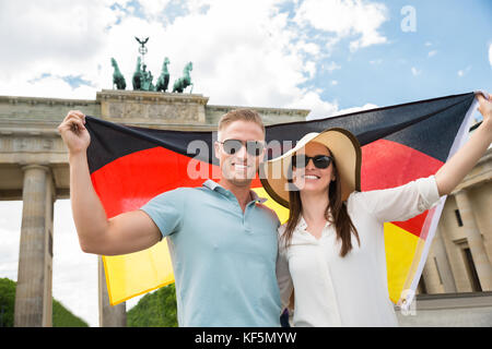 Lächelnden jungen Paar hält Fahne am Brandenburger Tor Stockfoto