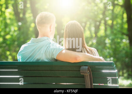 Rückansicht des Paares sitzen auf Bank im Park Stockfoto