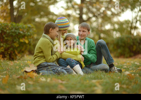 Mutter und Kinder entspannen im Park Stockfoto