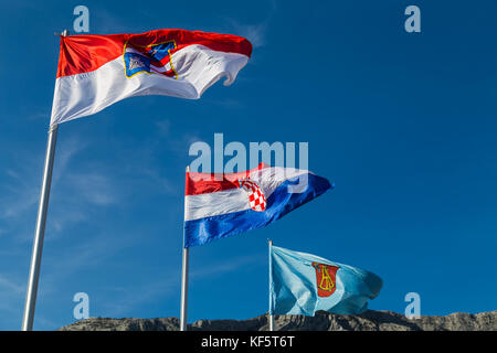 Drei bunte Fahnen in den Wind bei orebic Marina in Kroatien flattern. Sie umfassen Flagge von Dubrovnik - neretva County, Nationalflagge von Kroatien, Fla Stockfoto