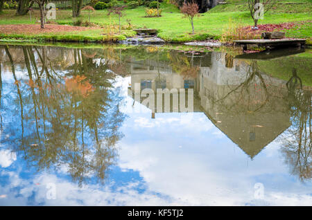 Reflexion der Bäume und Häuser im Herbst Teich helle Farben Stockfoto