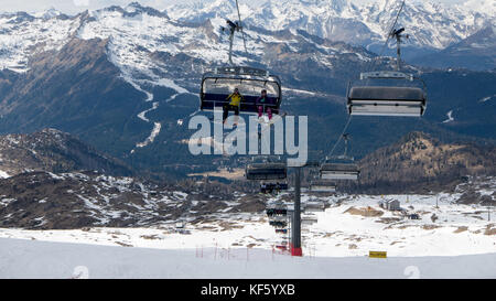 Madonna di campliglio, Italien - 8 apirl: Skifahrer und Snowboarder mit Skilift im beliebten Skigebiet Stockfoto