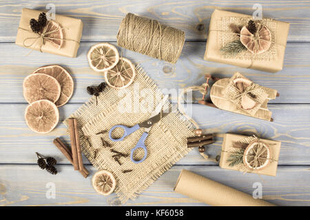 Im Alter von Foto, Zubehör, Dekoration, Holz- Schlitten und eingepackte Geschenke für Weihnachten oder anderen Feier liegen auf alten Boards Stockfoto