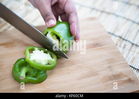Frau schneiden Paprika auf einem hölzernen Schneidebrett Stockfoto