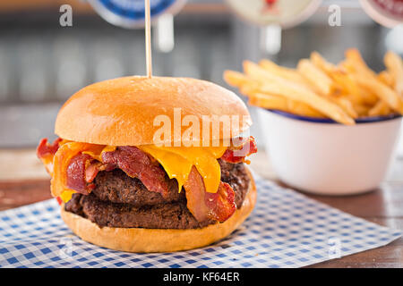 Doppel Beef Burger mit Käse und Speck, Schüssel Pommes frites Stockfoto