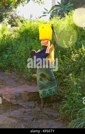 Leben im Slum in Kenia Aerias - Frau sammeln Trinkwasser von der Quelle Stockfoto