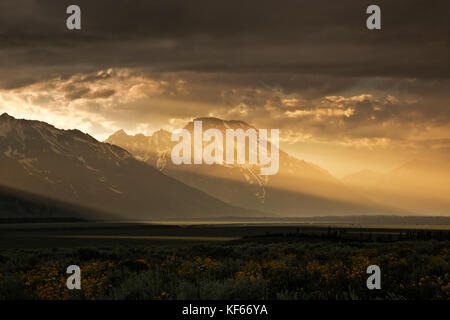 Wy 02496-00 ... Wyoming - Sonnenstrahlen, wie die Sonne an einem stürmischen Abend über den Tetons vom Antelope flats Wiesen an einem stürmischen Tag im Grand t Stockfoto