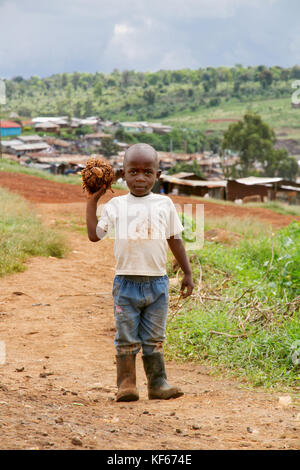 Leben im Slum in Kenia Aerias - Junge kid Spielen mit einem eigenen gemacht Fußball Stockfoto