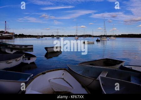 Boote und Spiegelungen im glänzenden Fluss Deben an einem strahlend sonnigen Oktobernachmittag. Waldringfield, Suffolk. Stockfoto