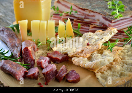 Typische Südtiroler Jause mit herzhaften geheilt Speck, Bergkäse, geräucherte Wurst und knusprigen Roggen Fladenbrot Stockfoto