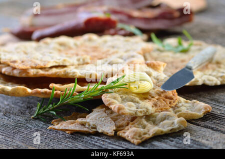 Südtiroler Brot Spezialität, sogenannte "chuettelbrot", eine sehr knusprig und trockenen Roggen Fladenbrot, oft mit geräuchertem Speck serviert und geräucherte Würste Stockfoto