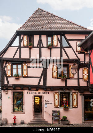 Feerie de Noel, ein Weihnachtsfachgeschäft in einem bemalten, mittelalterlichen Fachwerkgebäude im Dorf Riquewihr im Elsass, Frankreich. Stockfoto