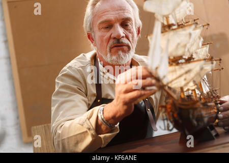 Der alte Mann ist ein Segelboot Modell Stockfoto