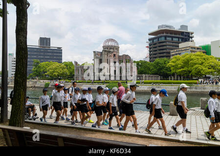 Hiroshima, Japan - 25. Mai 2017: Eine Gruppe von Studenten zu Fuß in Peace Memorial Park in Hiroshima mit der a-Bombe Dome im Hintergrund Stockfoto