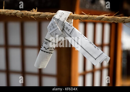 Hiroshima, Japan - 25. Mai 2017: Nahaufnahme eines Wahrsagen Streifen Papier gefesselt auf einem Seil, omikuji, es hinter sich gelassen, weil es vorausgesagt nicht gehen Stockfoto