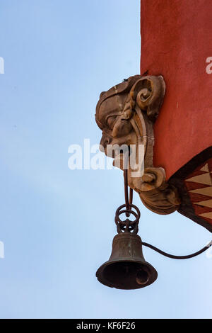 Glocke hängt von mascaron Kopf auf Gebäude Stockfoto