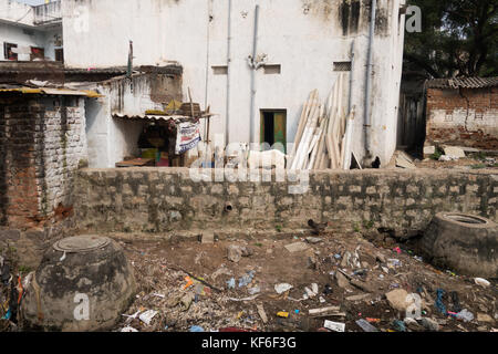 HYDERABAD, Indien - Oktober 22,2017 Haus mit einem Viehbestand im Hinterhof steht neben einem offenen Abwasserkanal in einem der ärmsten Viertel in Hyderabad, Stockfoto