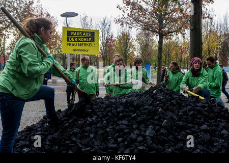 Berlin, Deutschland. Oktober 2017. Greenpeace-Aktivisten werden beobachtet, während sie während einer Demonstration die entladene Kohle auf dem Boden verteilen. Greenpeace-Aktivisten haben vor dem Kanzleramt in Berlin 10 Tonnen Kohle abgeladen. Mit der Aktion wollen sie ihre Nachfrage nach einem schnellen Kohleabgang ausleihen. Die künftige Klima- und Energiepolitik steht im Mittelpunkt der Sondierungsgespräche der Union, der FDP in Berlin in Jamaika. Quelle: Markus Heine/SOPA/ZUMA Wire/Alamy Live News Stockfoto