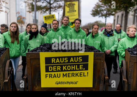 Berlin, Deutschland. 26 Okt, 2017. Greenpeace Aktivisten werden dargestellt mit einem Wagen voller Kohle während einer Demonstration. Greenpeace Aktivisten entladen haben 10 Tonnen Kohle vor dem Bundeskanzleramt in Berlin. Mit der Aktion wollen sie ihre Forderung für eine schnelle Kohle Ausstieg zu verleihen. Die Zukunft von Klima- und Energiepolitik steht im Mittelpunkt der Jamaika Sondierungsgespräche von Union und FDP in Berlin. Quelle: Markus Heine/SOPA/ZUMA Draht/Alamy leben Nachrichten Stockfoto