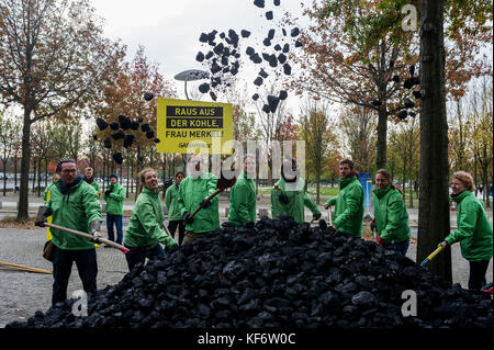 Berlin, Deutschland. Oktober 2017. Greenpeace-Aktivisten werden beobachtet, während sie während einer Demonstration die entladene Kohle auf dem Boden verteilen. Greenpeace-Aktivisten haben vor dem Kanzleramt in Berlin 10 Tonnen Kohle abgeladen. Mit der Aktion wollen sie ihre Nachfrage nach einem schnellen Kohleabgang ausleihen. Die künftige Klima- und Energiepolitik steht im Mittelpunkt der Sondierungsgespräche der Union, der FDP in Berlin in Jamaika. Quelle: Markus Heine/SOPA/ZUMA Wire/Alamy Live News Stockfoto