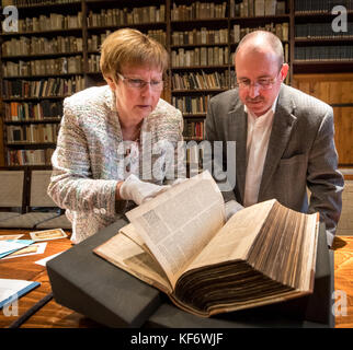 Erfurt, Deutschland. Oktober 2017. Bibliotheksdirektor Michael Ludscheidt und Restaurierungsexpertin Elke Wilcke mit einer restaurierten, fast 500 Jahre alten Lutherbibel im Augustinerkloster in Erfurt, 26. Oktober 2017. Die Bibel wurde 1540 von Hans Lufft gedruckt. Sie wurde mit Mitteln der thüringischen Landeskanzlei und einer Bibliothekstiftung restauriert. Quelle: Arifoto UG/Michael Reichel/dpa-Zentralbild/dpa/Alamy Live News Stockfoto