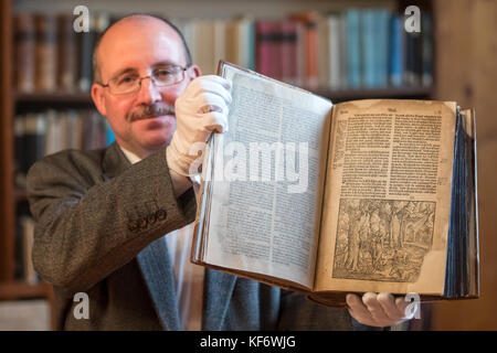 Erfurt, Deutschland. Oktober 2017. Bibliotheksdirektor Michael Ludscheidt hält am 26. Oktober 2017 eine restaurierte, fast 500 Jahre alte Lutherbibel im Augustinerkloster in Erfurt. Die Bibel wurde 1540 von Hans Lufft gedruckt. Sie wurde mit Mitteln der thüringischen Landeskanzlei und einer Bibliothekstiftung restauriert. Quelle: Arifoto UG/Michael Reichel/dpa-Zentralbild/dpa/Alamy Live News Stockfoto