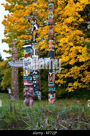 Totempfähle im Stanley Park, Vancouver, mit bunten Bäume im Herbst. Stockfoto