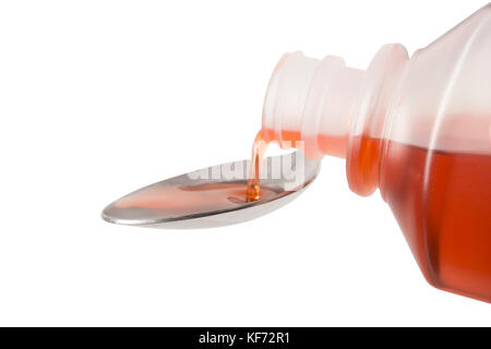 Eine Flasche roten Hustenmedizin auf einem Löffel gegossen, auf der Vorderseite der Löffel konzentriert Stockfoto