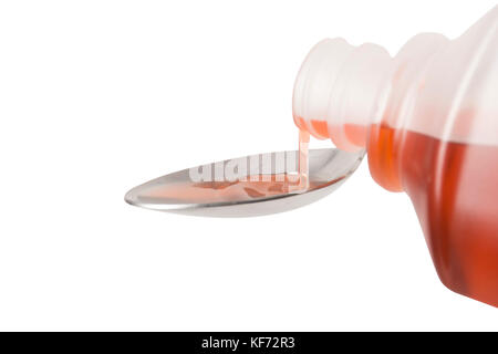 Eine Flasche roten Hustenmedizin auf einem Löffel gegossen wird, auf der Rückseite der Löffel konzentriert Stockfoto