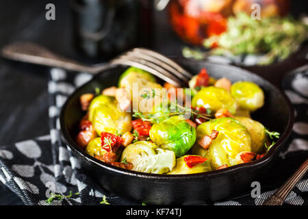 Gerösteter Rosenkohl mit Speck und getrocknete Tomaten in Pan Stockfoto