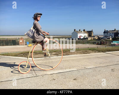 Frencesca Daisy-Hill fährt mit einem Penny Farthing-Fahrrad während der Teilnahme an einer Wohltätigkeitsfahrradfahrt „Tour de Rye et Romney Marsh“ für Kent und Sussex Air Ambulance auf der Meeresmauer zwischen Camber & Lydd in Kent, Großbritannien mit: Atmosphäre Where: Lydd, Kent, Vereinigtes Königreich Wann: 24 Sep 2017 Credit: Clare Calcott-James/Cover Images Stockfoto