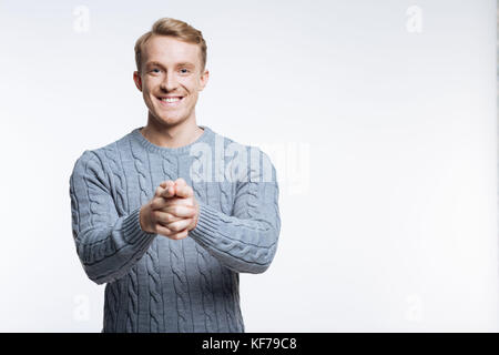 Schönen blonden Mann in Pullover bei Camera pointing Stockfoto