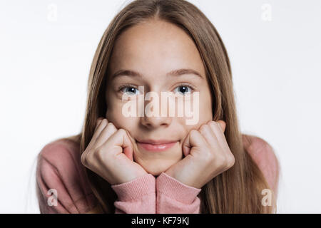 Blonde Jugendmädchen ihr Kinn auf die Hände Stockfoto