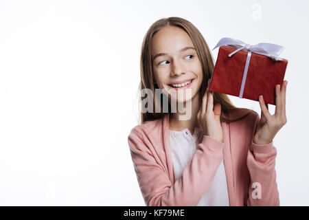 Cute Jugendmädchen peeking im Geschenkkarton Stockfoto