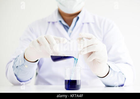 Wissenschaftler und wissenschaftliche Ausrüstung Gießen mischen Reagenzien liqiud Becher, Labor, Forschung Chemie Konzept Stockfoto
