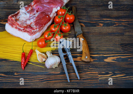 Rohes Fleisch saftige Steaks bereit für Braten auf einem schwarzen Kreidetafel Hintergrund. Rib Eye Steak auf den Knochen, kalbshaxe Ossobuco, Filet mit Cherry Tomaten Stockfoto