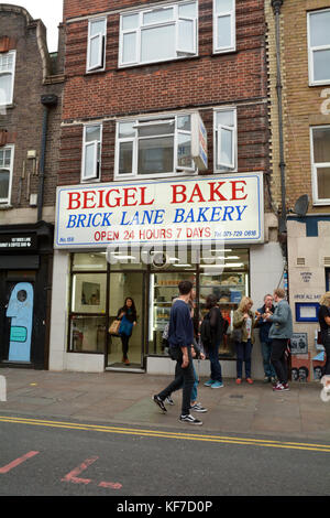 Menschen essen Bagels außerhalb des beliebten Beigel Bake - Eine 24-shop in Brick Lane London England Stockfoto