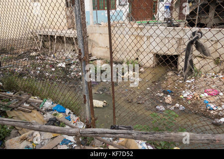 HYDERABAD, Indien - Oktober 22,2017 Stahl Drahtgitter Zaun entlang der offenen Abwasserkanal Bewohner von Müll werfen in es in H abzuschrecken installiert Stockfoto