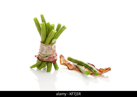 Grüne Bohnen mit Speck auf weißem Hintergrund mit Reflexion isoliert. gesunden Hülsenfrüchte. Stockfoto