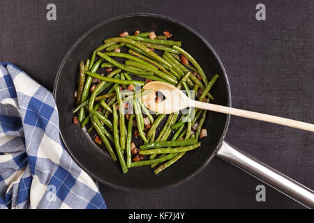 Gesunde grüne Bohnen mit Speck in der Pfanne von oben. Gesundes Kochen Konzept. Stockfoto