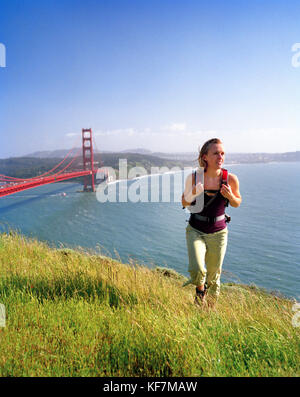 Usa, Kalifornien, Marin headlands, Frau, wandern über die Golden Gate Bridge mit San Francisco im Abstand Stockfoto