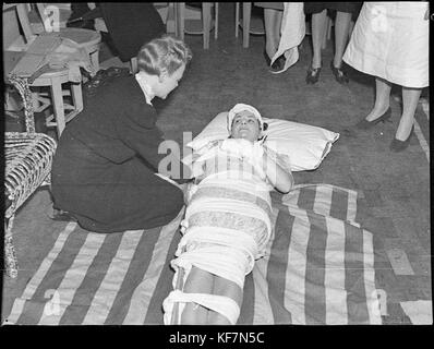 Dieses Bild dokumentiert eine erste-Hilfe-Schulung, die am Grace Bros Broadway stattfand und in der Mitte des 20. Jahrhunderts medizinische Notfallpraxen und Gesundheitserziehung vorgestellt werden. Stockfoto