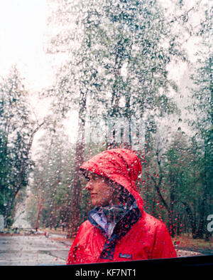 Usa, Kalifornien, Yosemite National Park, eine junge Frau in roter Regenjacke Stockfoto