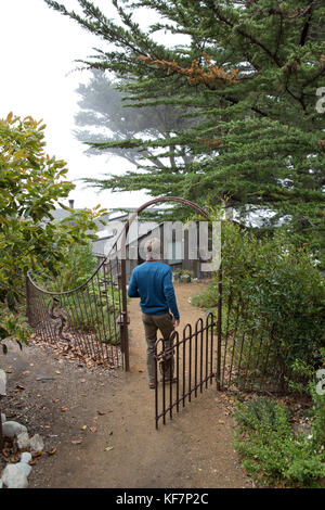 Usa, Kalifornien, Big Sur, Esalen, ein Mann durch ein Tor zu den Häusern am Esalen Institut Stockfoto