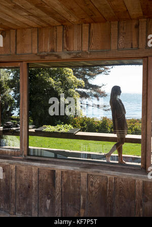 Usa, Kalifornien, Big Sur, Esalen, eine Reflexion von einer Frau zu Fuß vor der Buchhandlung mit dem Pazifischen Ozean in der Ferne, die esalen Institut Stockfoto